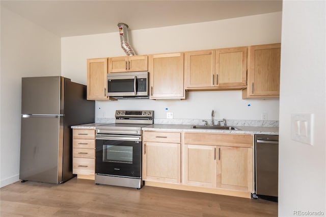 kitchen with light hardwood / wood-style floors, sink, light brown cabinets, and appliances with stainless steel finishes