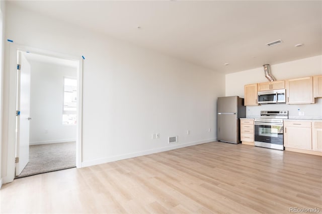 kitchen featuring stainless steel appliances, light hardwood / wood-style flooring, and light brown cabinets