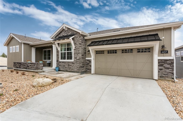 6657 S Kline Way, Littleton, CO 80127 - view of front facade featuring stone siding, driveway, an attached garage, a standing seam roof, and metal roof