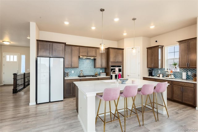6657 S Kline Way, Littleton, CO 80127 - kitchen with freestanding refrigerator, gas cooktop, light wood-type flooring, decorative backsplash, and recessed lighting