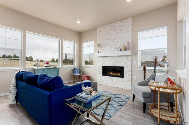 6657 S Kline Way, Littleton, CO 80127 - living area with wood finished floors, a stone fireplace, recessed lighting, and baseboards