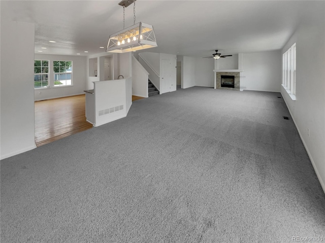 16453 E Phillips Dr, Englewood, CO 80112 - unfurnished living room featuring a fireplace, stairway, ceiling fan, carpet flooring, and recessed lighting