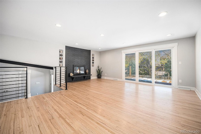 unfurnished living room featuring a fireplace and light wood-type flooring