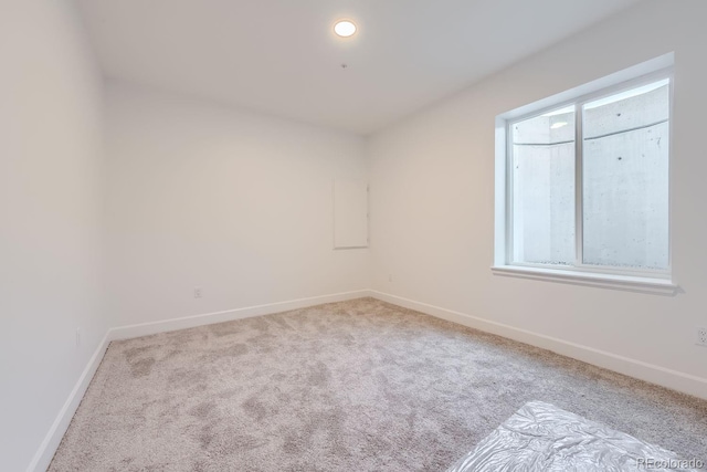 empty room with light colored carpet and a healthy amount of sunlight