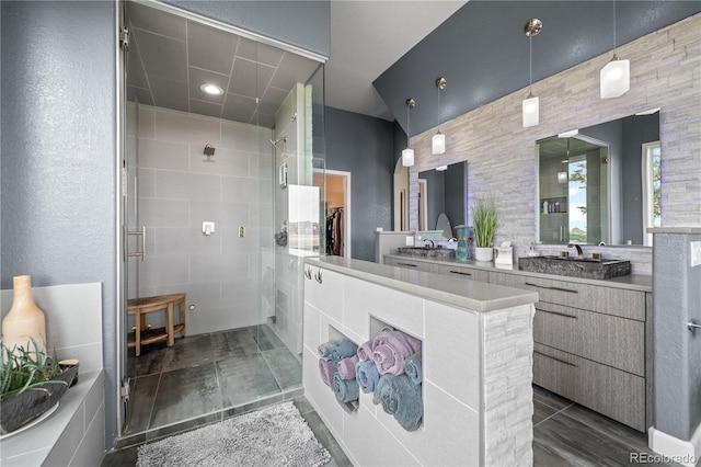 bathroom with vanity, a walk in closet, and a stall shower