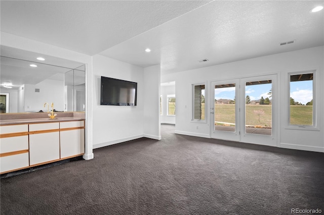 unfurnished living room with visible vents, dark carpet, and recessed lighting
