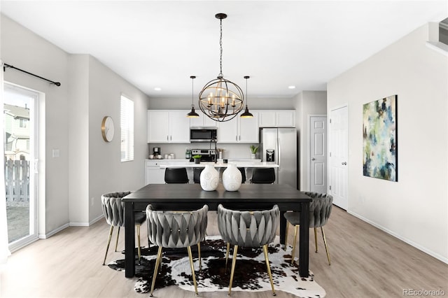 dining area with an inviting chandelier, recessed lighting, light wood-style floors, and baseboards