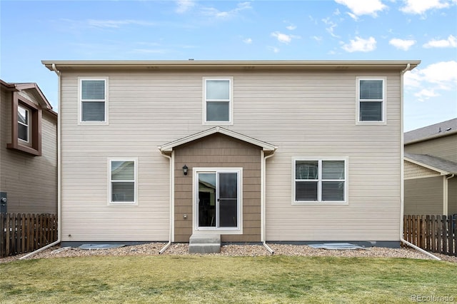 rear view of property with a yard and fence