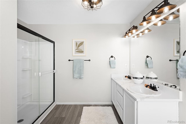 full bathroom with a stall shower, wood finished floors, and a sink