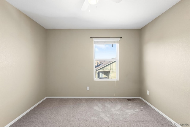 carpeted empty room featuring visible vents, ceiling fan, and baseboards