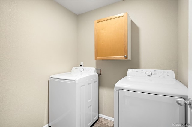 washroom with washer and clothes dryer and cabinet space