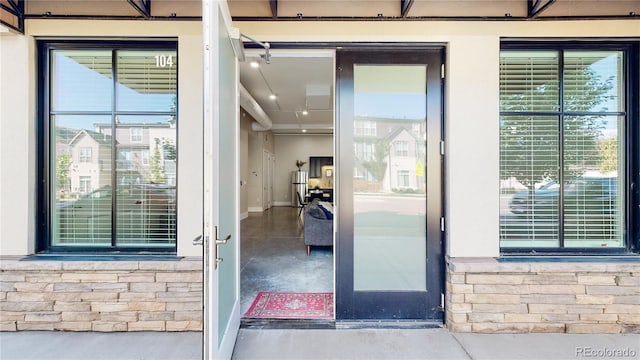 property entrance featuring stone siding and stucco siding