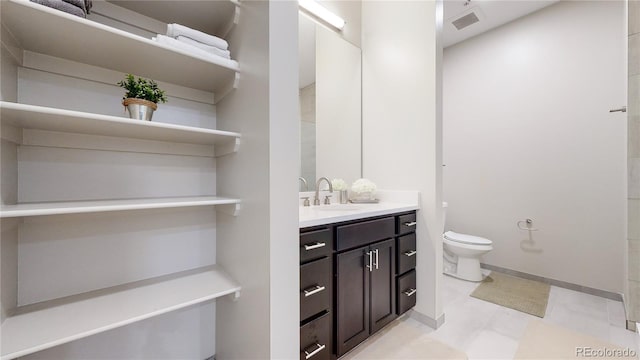 bathroom featuring baseboards, visible vents, vanity, and toilet