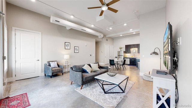 living area with finished concrete flooring, a high ceiling, a ceiling fan, and recessed lighting