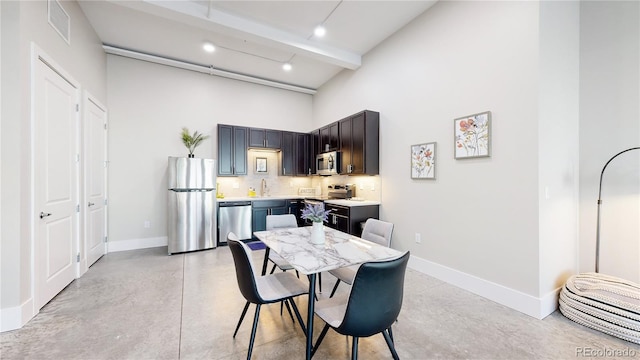 dining area featuring finished concrete floors, visible vents, beamed ceiling, and baseboards