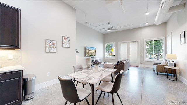 dining area with baseboards, a ceiling fan, rail lighting, finished concrete floors, and french doors