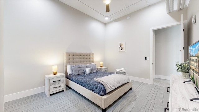 bedroom featuring light wood-style flooring, baseboards, and a ceiling fan