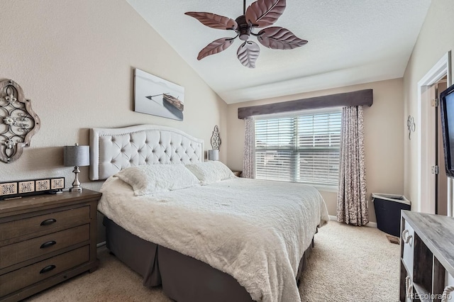 bedroom with vaulted ceiling, ceiling fan, a textured ceiling, and light colored carpet