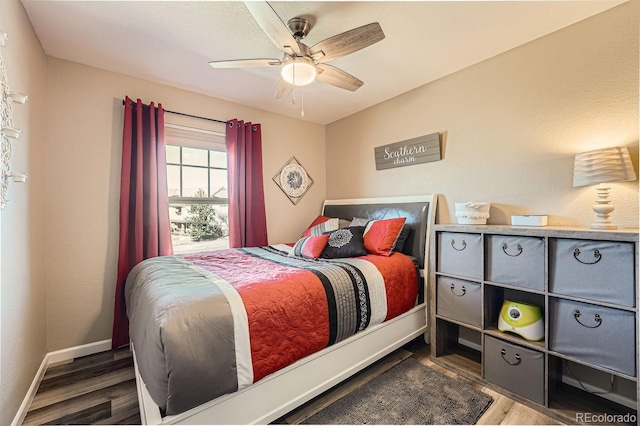 bedroom featuring ceiling fan, baseboards, and wood finished floors