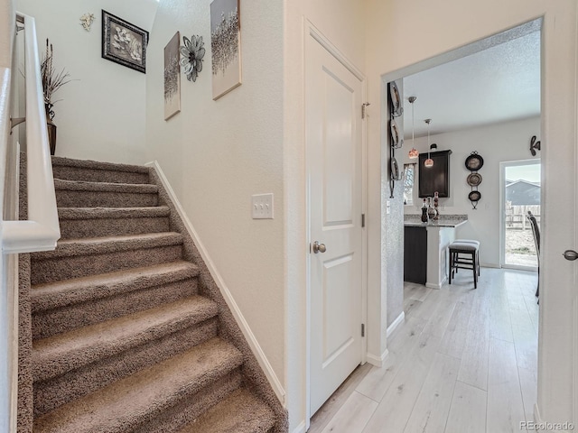 staircase featuring wood-type flooring and a textured ceiling