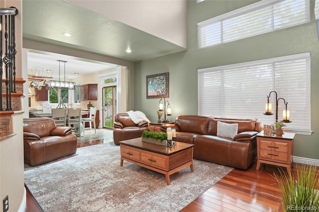 living area featuring hardwood / wood-style floors, a chandelier, baseboards, and recessed lighting