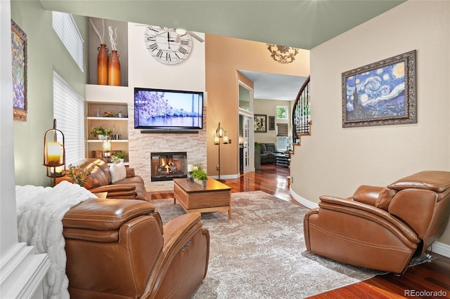 living area with wood finished floors, a fireplace, and baseboards