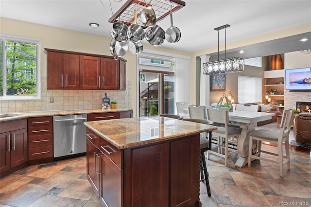 kitchen with dishwasher, decorative backsplash, stone tile floors, and light stone countertops