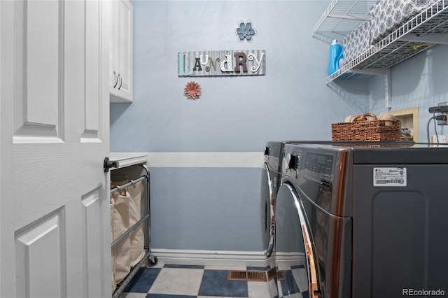 washroom with separate washer and dryer, cabinet space, baseboards, and tile patterned floors