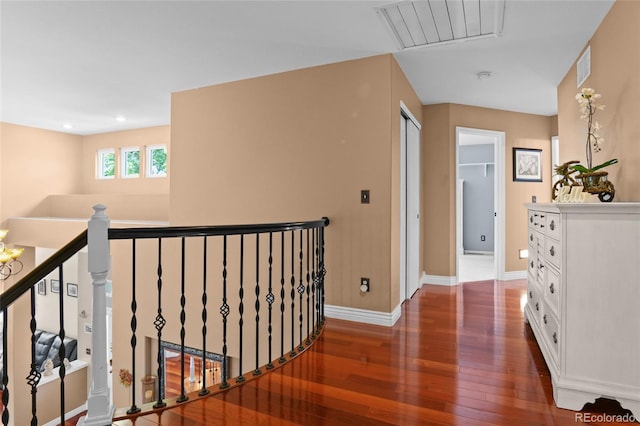 corridor with wood finished floors, baseboards, an upstairs landing, recessed lighting, and attic access