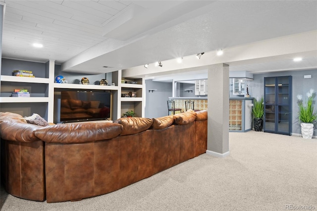 living room with carpet, baseboards, bar area, and built in features
