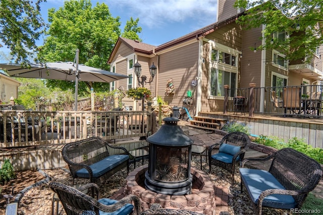 view of patio featuring an outdoor fire pit and a deck