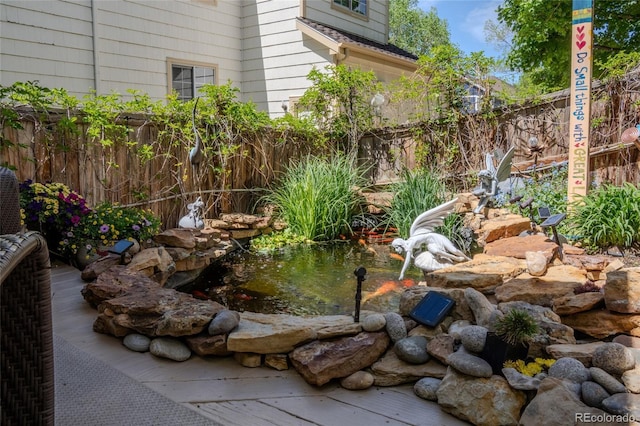 view of yard with a small pond and fence