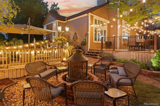 view of patio with a deck and an outdoor living space with a fire pit