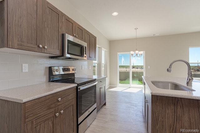 814 N Bently St, Watkins, CO 80137 - kitchen with appliances with stainless steel finishes, a sink, plenty of natural light, a chandelier, and recessed lighting