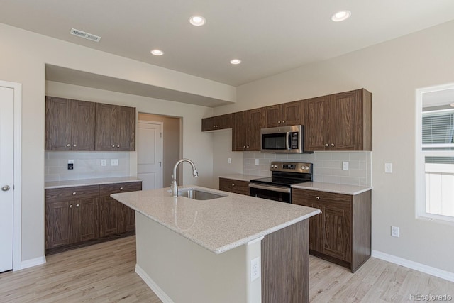 814 N Bently St, Watkins, CO 80137 - kitchen with stainless steel appliances, a sink, light wood-style floors, tasteful backsplash, and recessed lighting