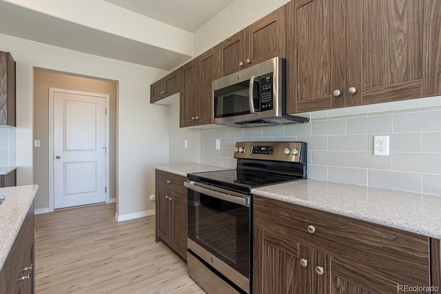814 N Bently St, Watkins, CO 80137 - kitchen with stainless steel appliances, decorative backsplash, light wood-style floors, and baseboards