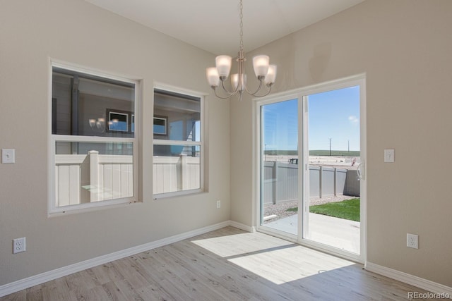 814 N Bently St, Watkins, CO 80137 - unfurnished room with wood finished floors, a chandelier, and baseboards