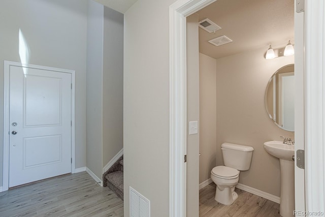 814 N Bently St, Watkins, CO 80137 - bathroom with wood finished floors, toilet, baseboards, and a sink