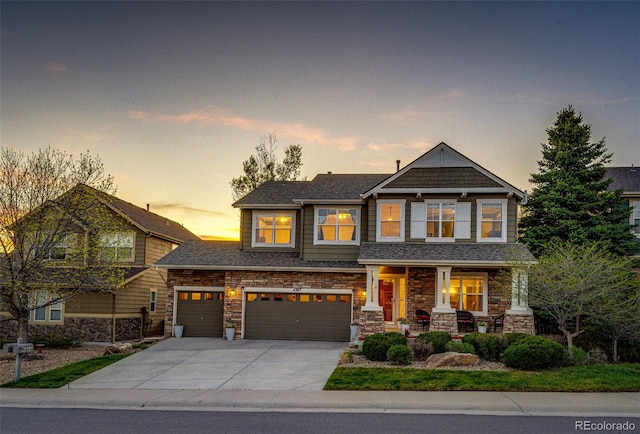 craftsman house featuring driveway, covered porch, a garage, and stone siding