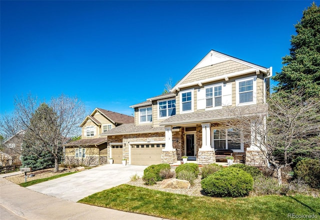 craftsman house featuring driveway, a garage, stone siding, and covered porch