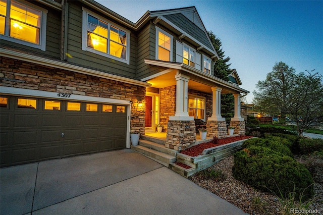 craftsman house featuring a porch, stone siding, an attached garage, and driveway