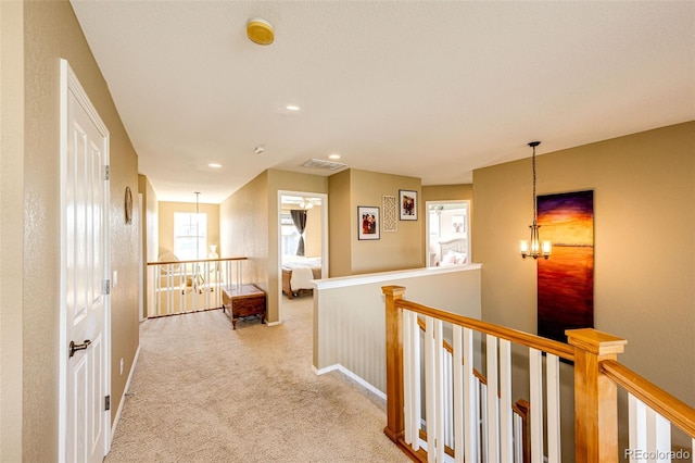 hall featuring an upstairs landing, light carpet, a chandelier, recessed lighting, and baseboards