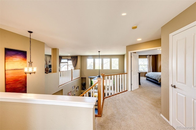 hall with an upstairs landing, carpet floors, healthy amount of natural light, and recessed lighting