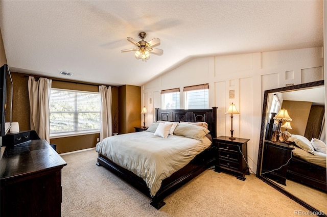 bedroom featuring light carpet, lofted ceiling, a textured ceiling, ceiling fan, and baseboards