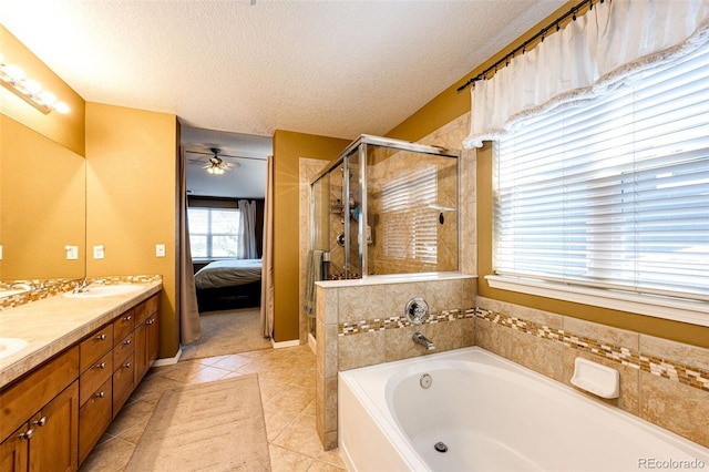 ensuite bathroom featuring a textured ceiling, a stall shower, a bath, double vanity, and a ceiling fan