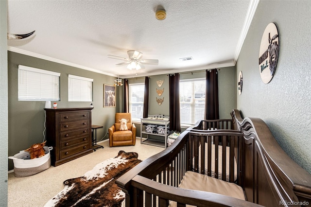 bedroom featuring ornamental molding, a textured ceiling, carpet floors, a textured wall, and a crib
