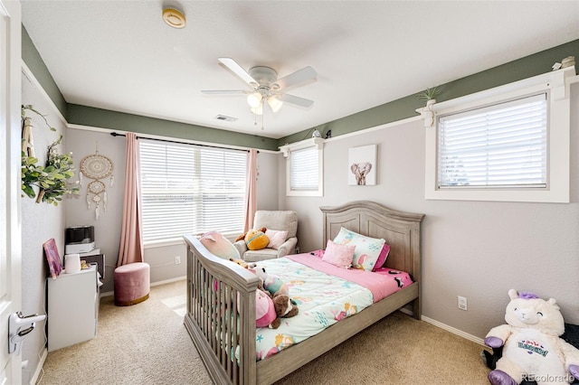 bedroom with light colored carpet, baseboards, and a ceiling fan