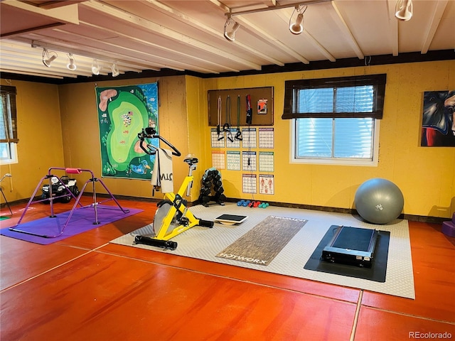 workout area featuring track lighting and baseboards