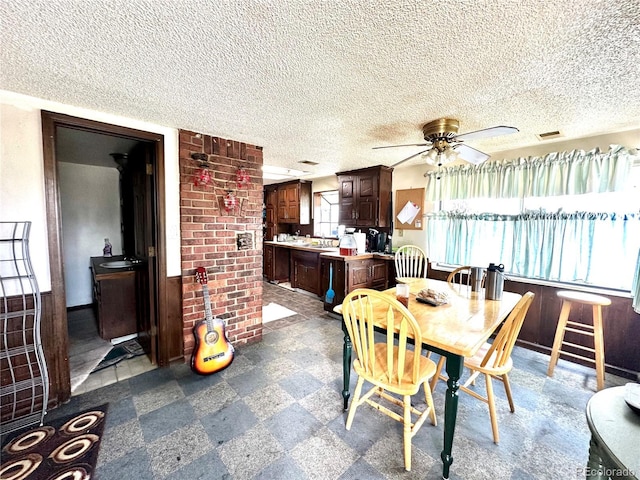 dining area with dark flooring, a ceiling fan, and a textured ceiling