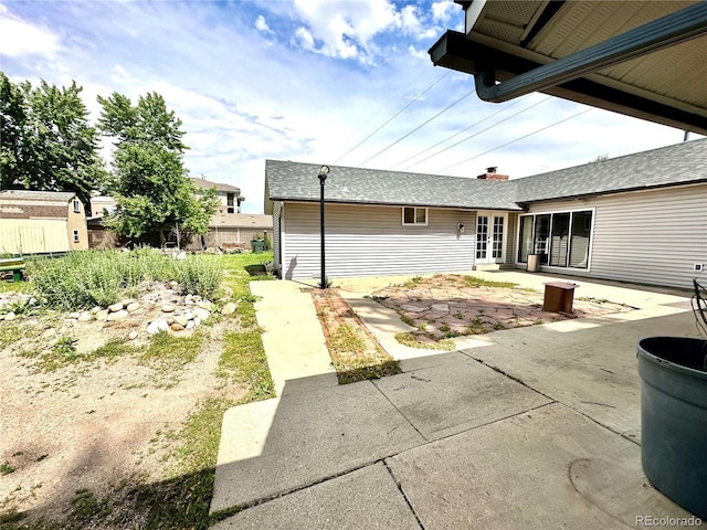 back of property with a patio and a shed